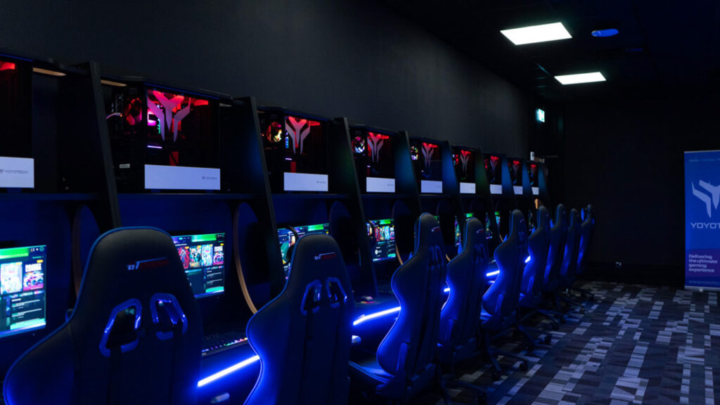 Fully installed school esports arena design by Yoyotech, featuring a row of custom gaming PCs and ergonomic furniture with blue LED lighting.
