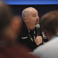 Closeup of Nik Turner holding a microphone.
